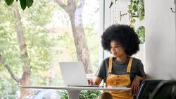 Young happy african american woman on her laptop